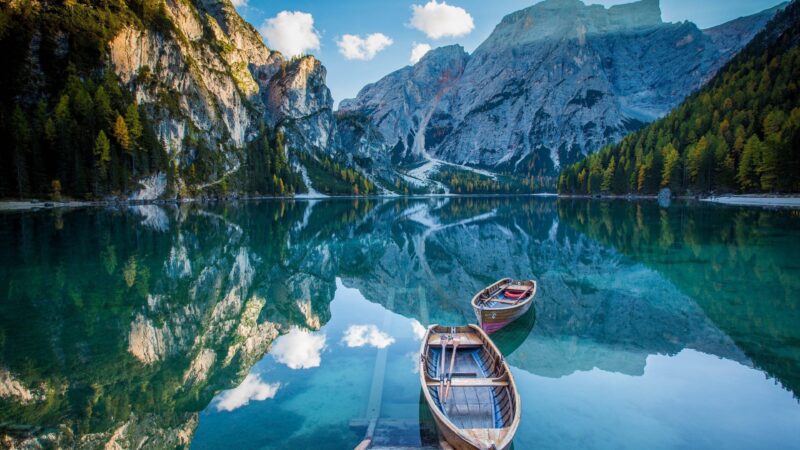 Serenity of Wooden Boats on Mirror Lake 4K Wallpaper