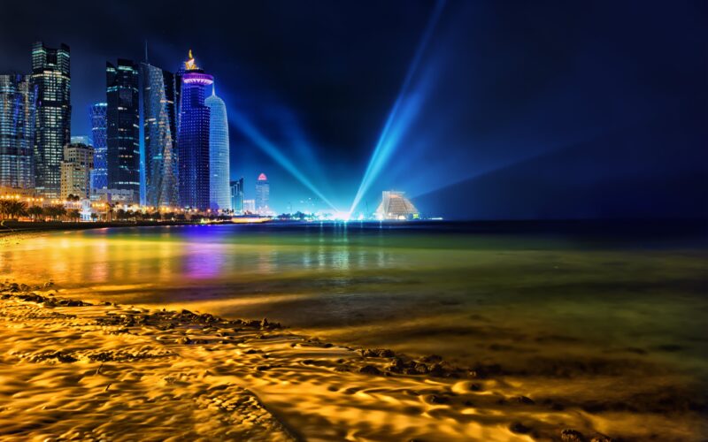 Doha's Luminous Night: Skyscrapers & Radiant Beams 4K Wallpaper